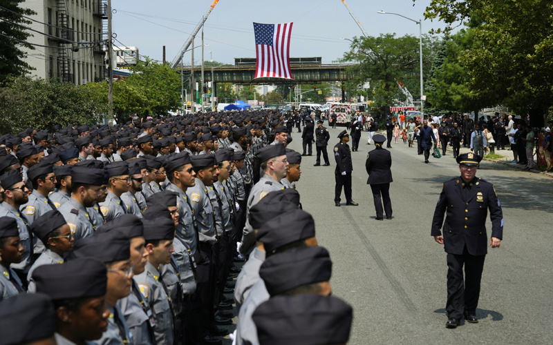 Mourners honor the NYPD officer killed in Monday's attack at NFL office