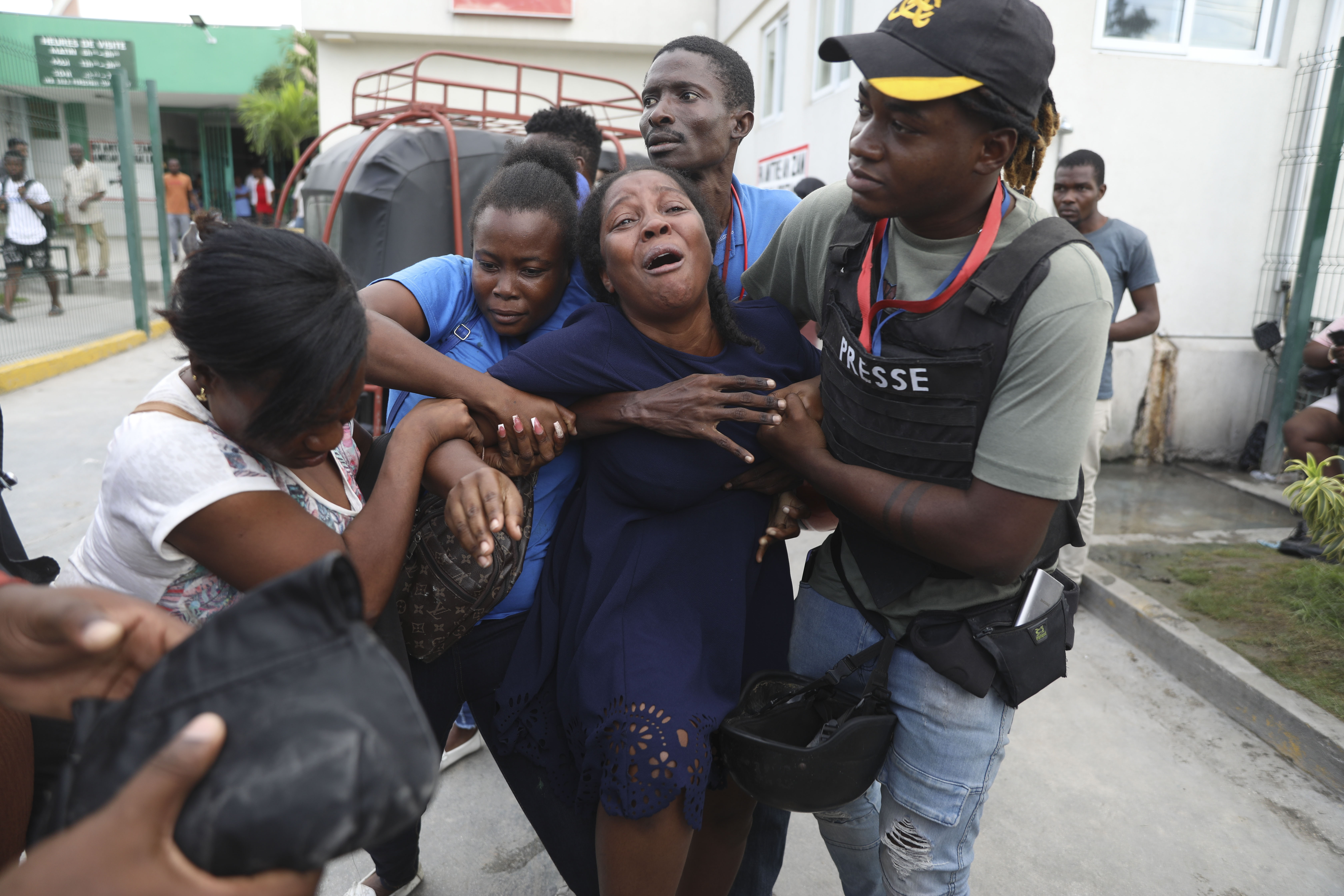 A Haiti gang attack on the reopening of a main hospital kills 2 reporters and a police officer